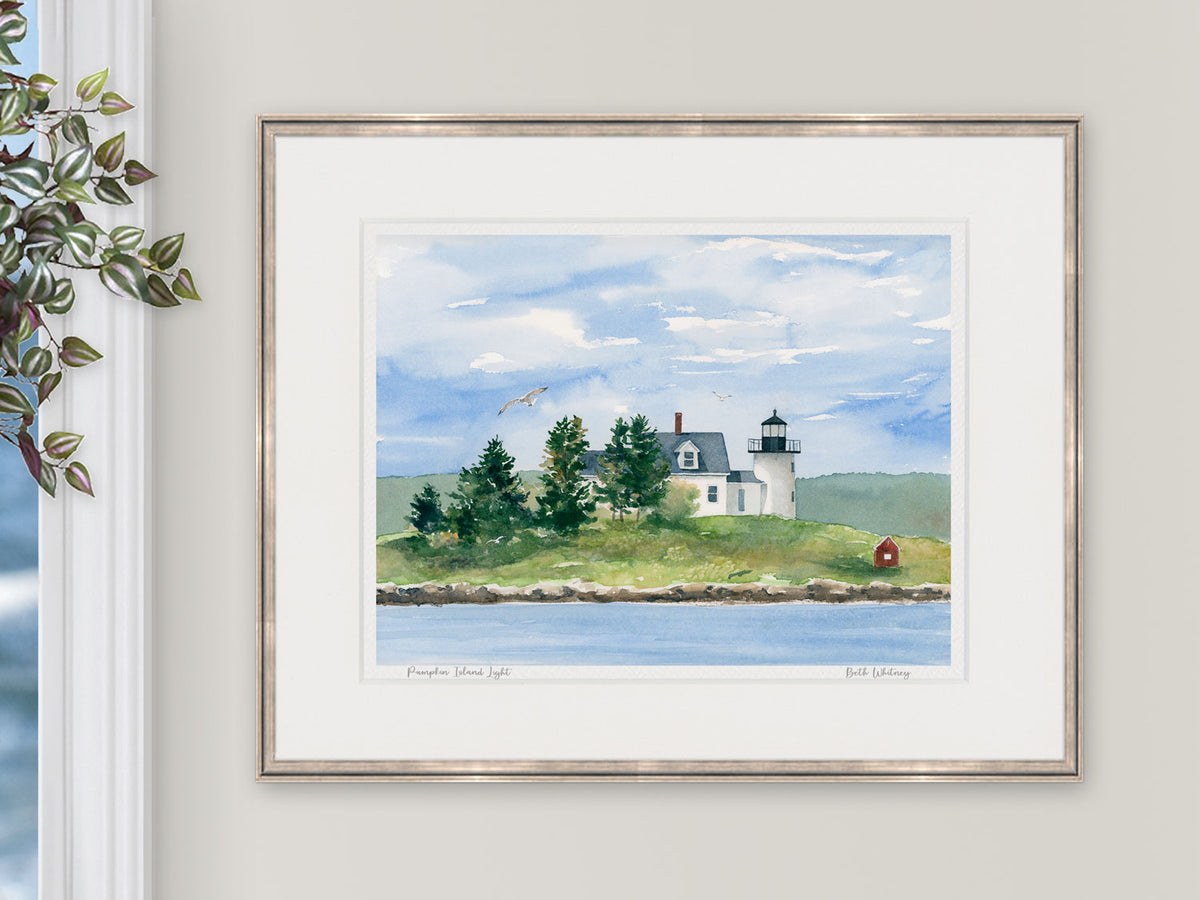 Framed watercolor print of Pumpkin Island Light, Eggemoggin Reach, Maine, in a warm rose gold frame with natural window light.