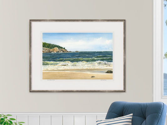 Framed watercolor print of Sand Beach Surf, Acadia National Park, Maine, in a gold frame with blue chair in a nautical lifestyle setting.