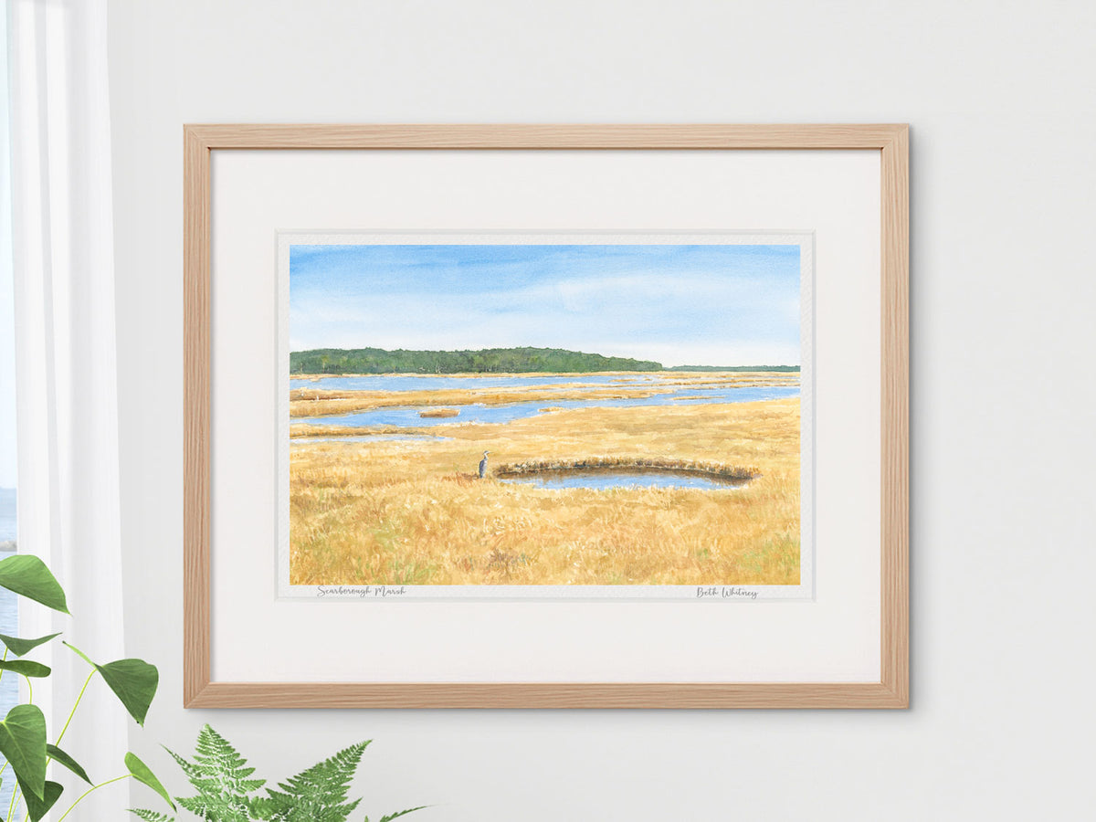 Framed watercolor print of Scarborough Marsh, Southern Maine, in a warm wood frame with lush plant styling.