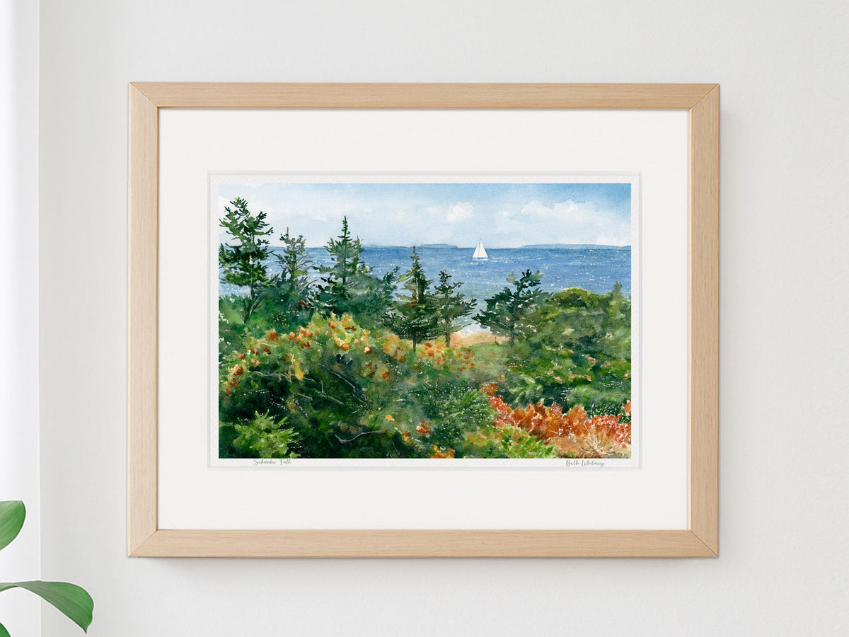 Framed watercolor print of Schoodic Fall, Schoodic Point, Acadia, in a warm wood frame on a neutral wall.