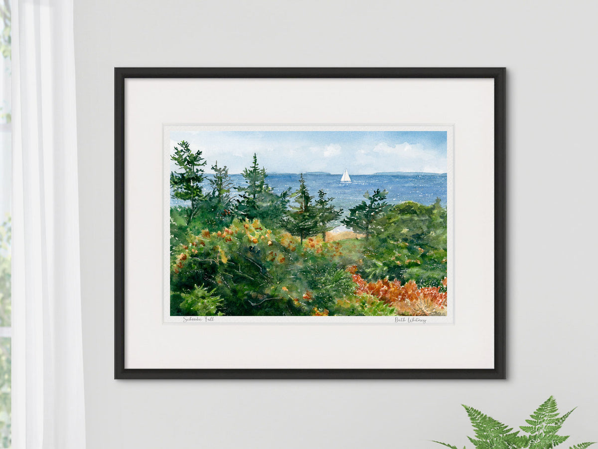 Framed watercolor print of Schoodic Fall, Acadia National Park, in a contemporary black frame on a neutral wall.