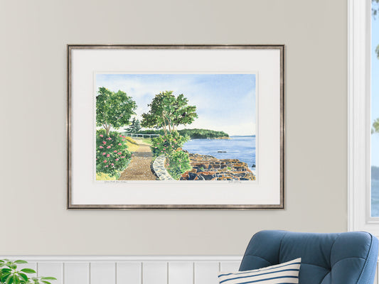 Framed watercolor print of Shore Path Bar Harbor, Maine, in a warm wood frame in a nautical inspired bedroom lifestyle setting.