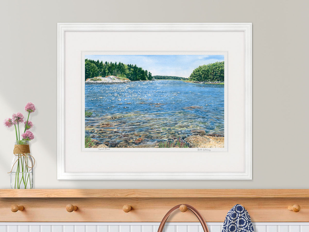 Framed watercolor print of Spirit Pond, Phippsburg, Maine, in a white frame in a kitchen decor setting.