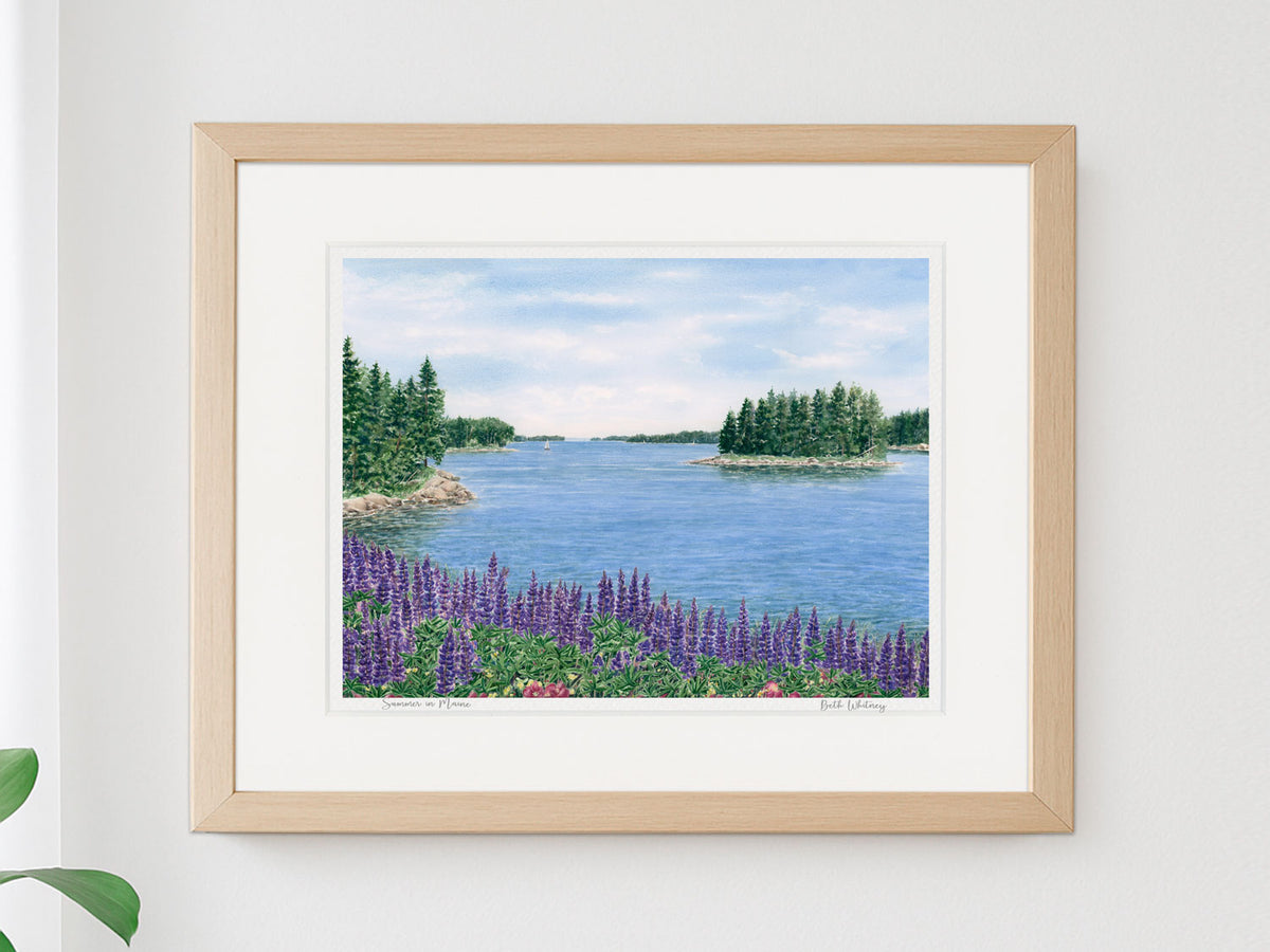 Framed watercolor print of Summer in Maine, Deer Isle, Maine, in a natural wood frame on a brightly lit, neutral home decor.