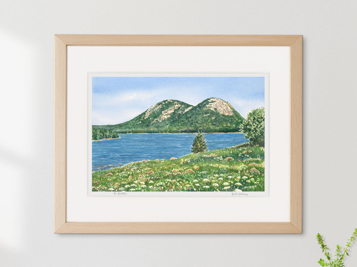 Framed watercolor print of The Bubbles, Jordan Pond, Acadia National Park, in a simple wood frame on a sunny wall.