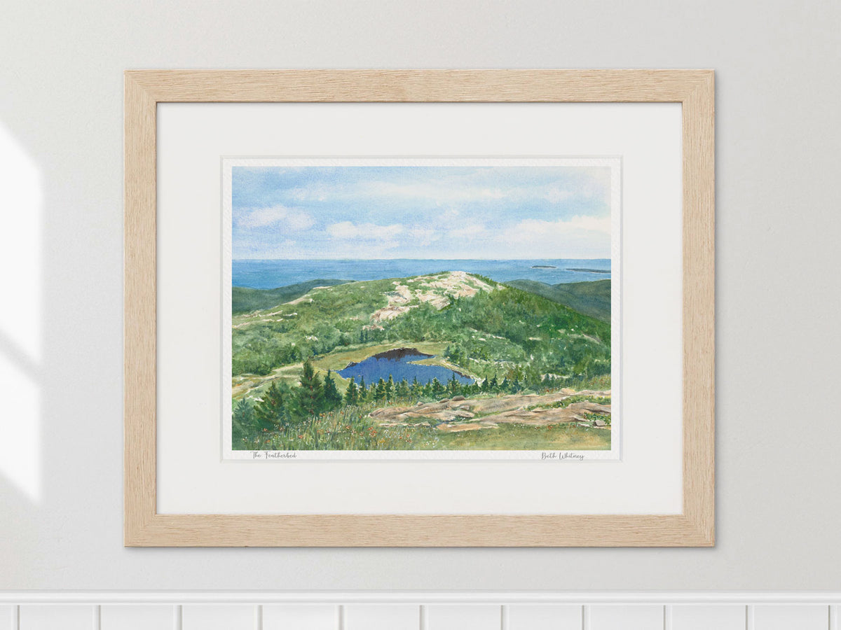 Framed watercolor print of The Featherbed, Cadillac Mountain, in a warm wood frame on a neutral wall.