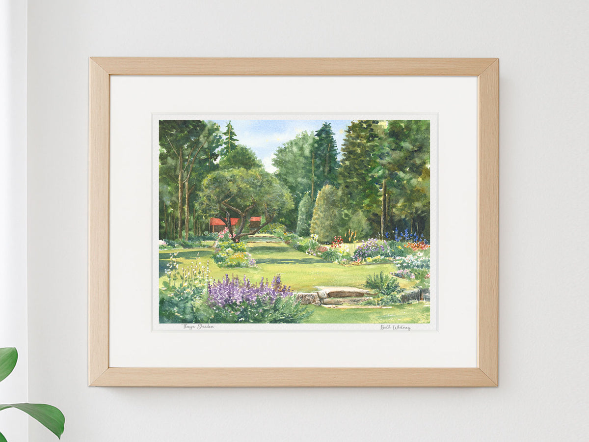Framed watercolor print of Thuya Garden, Northeast Harbor, Maine, in a warm wood frame on a neutral wall.