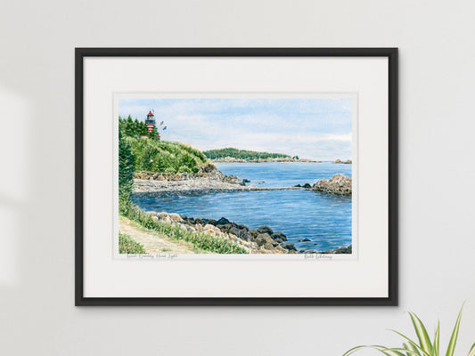 Framed watercolor print of West Quoddy Head Light, Lubec, Maine, in a black frame on a sunny neutral wall.