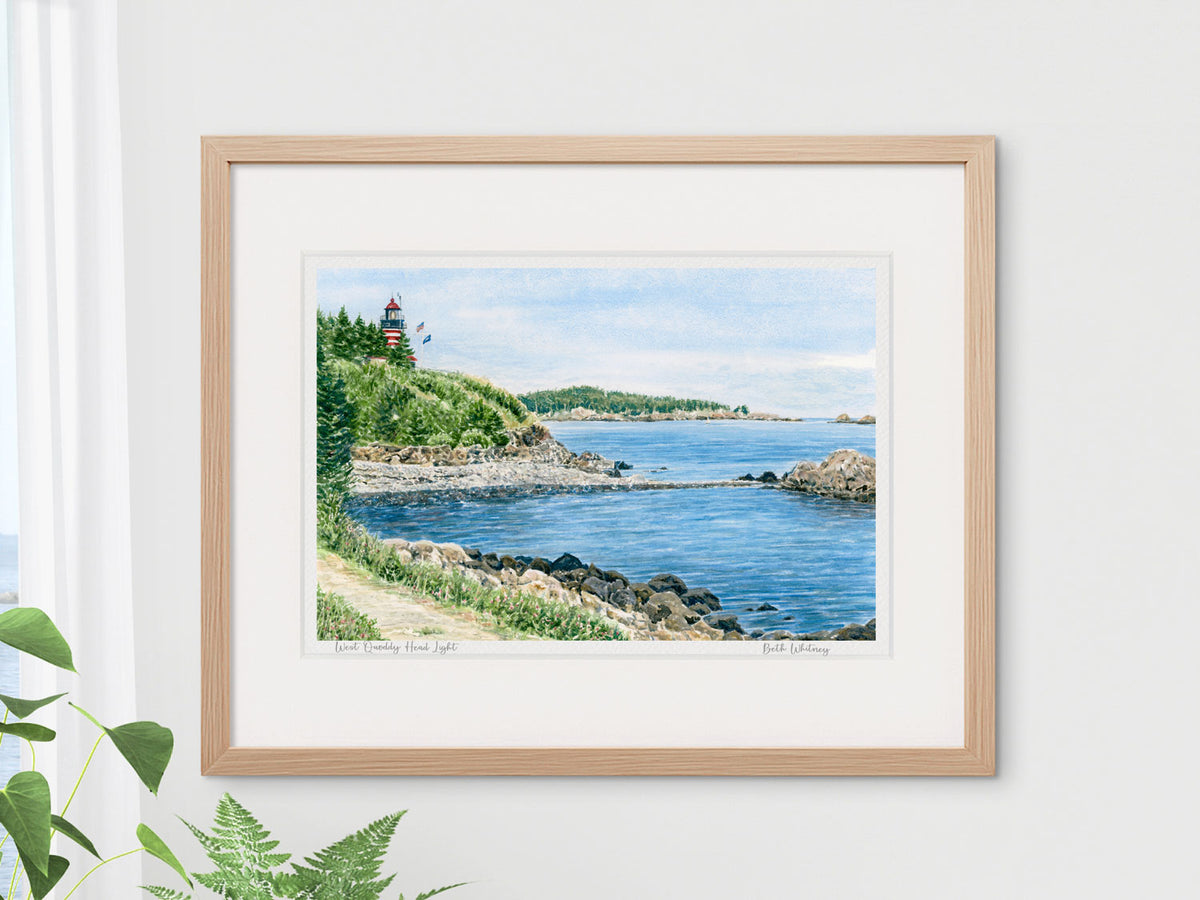 Framed watercolor print of West Quoddy Head Light, Downeast Maine, in a warm wood frame with plant styling.