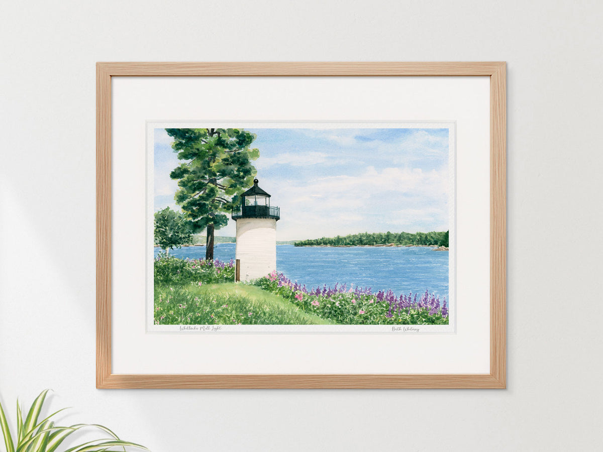 Framed watercolor print of Whitlocks Mill Light, Calais, Maine, in a warm wood frame on a neutral wall.
