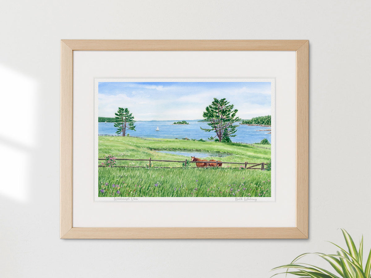 Framed watercolor print of Windswept View, East Blue Hill, Maine, in a warm wood frame on a neutral home decor.