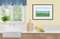Watercolor painting of Bar Harbor, Maine and islands from Cadillac Mountain. Shown in a kitchen with wood cabinets.