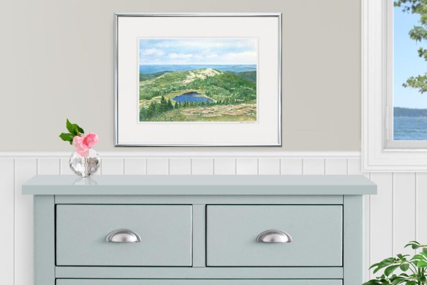 Watercolor mountaintop view of the ocean and a glacial pond in Acadia. Displayed in a bedroom.