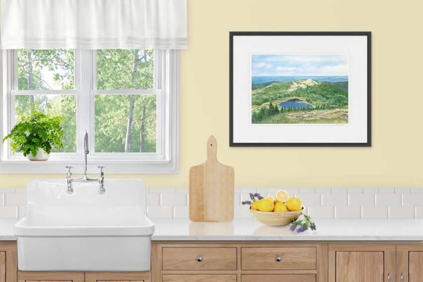 Watercolor mountaintop view of the ocean and a glacial pond in Acadia. Displayed in a kitchen.