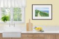 Watercolor of seaside cottage with path along the ocean, winding through grass and wildflowers, shown in a kitchen.